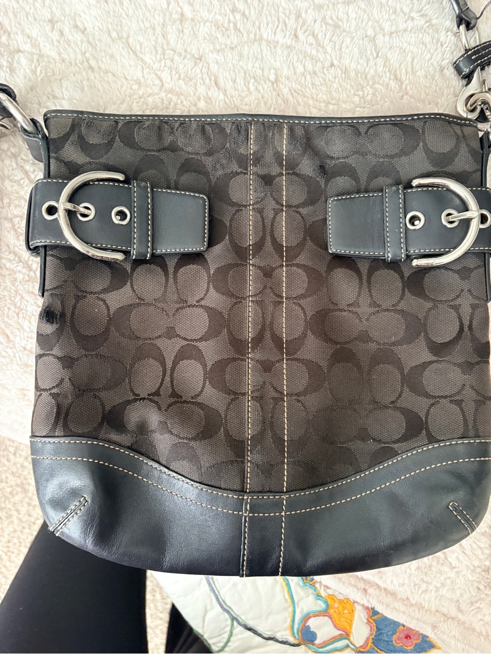 Black Coach Signature Soho shoulder bag with jacquard canvas and silver buckles.